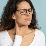 woman touching her sore throat due to air conditioning dryness
