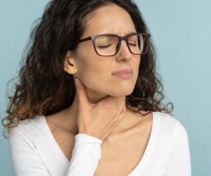 woman touching her sore throat due to air conditioning dryness