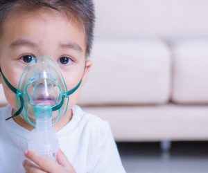 little boy wearing a breathing machine mask for bronchitis relief