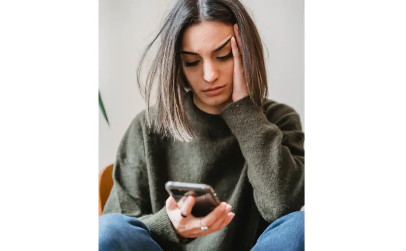 Young woman looking concerned while reading about air purifiers on her phone