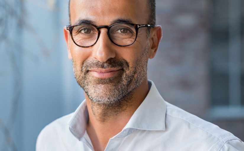 A man smiling because he's found a simple way to clean AC coils without removing anything.