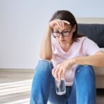 Frustrated woman waiting for CPAP repair after machine stopped working from using tap water instead of distilled